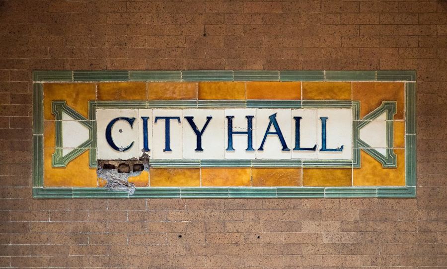 The original faience 'City Hall' name tablet on the wall of the abandoned City Hall subway station