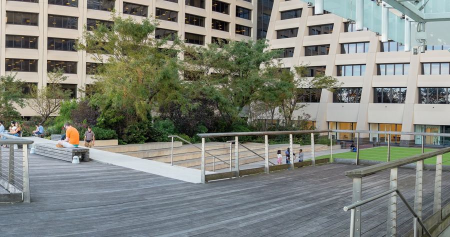 The lawn and boardwalk of the Elevated Acre above 55 Water Street, framed by office towers