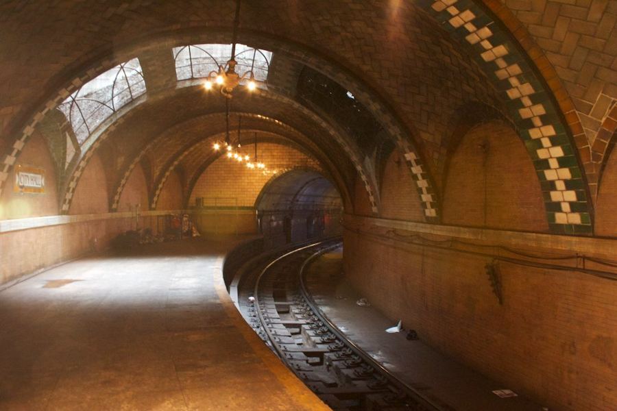The curved platform of the abandoned City Hall station, its tiled arches, skylights and a brass chandelier lit above the track