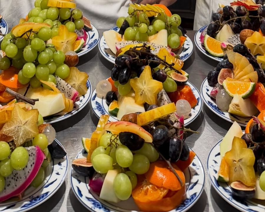 Fruit plates at Bonnie's: grapes, star fruit, dragon fruit, figs and mandarins on blue-and-white plates
