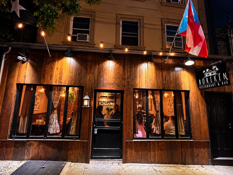The wood-clad front of Borikén Restaurant & Bar on Bay Street at dusk, with a Puerto Rican flag over the door