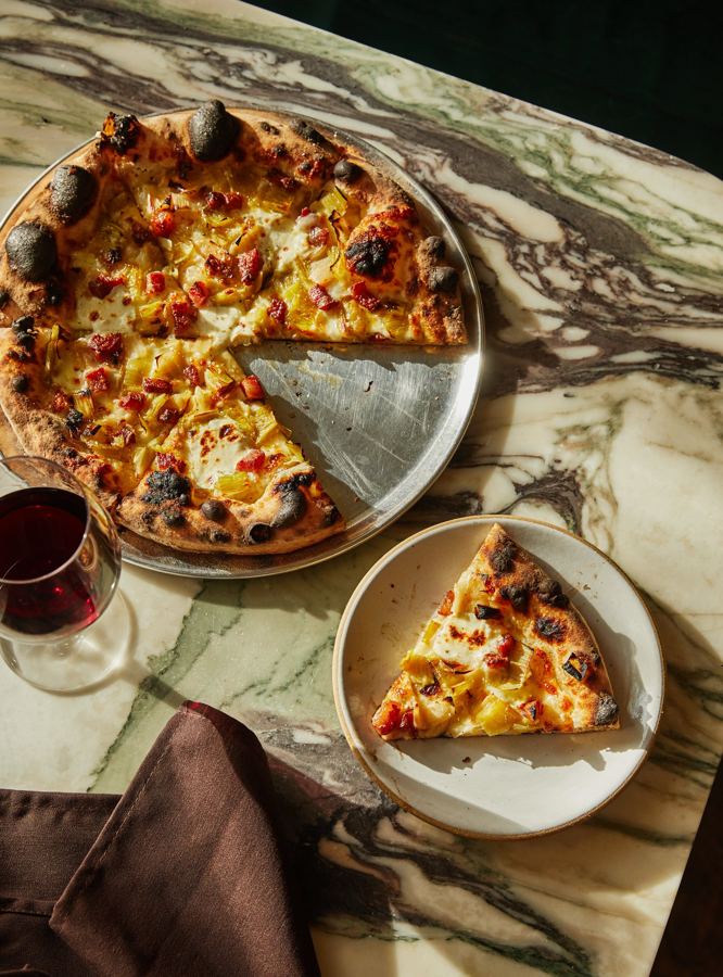 A pie on a green marble table, one slice on the plate