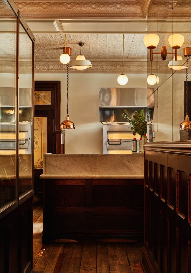 The open kitchen and bar, under warm pendant lights