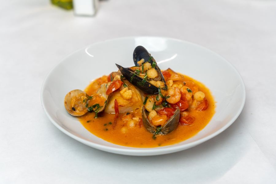 Zuppa di pesce with mussels, clams and shrimp in a white bowl at F & J Pine
