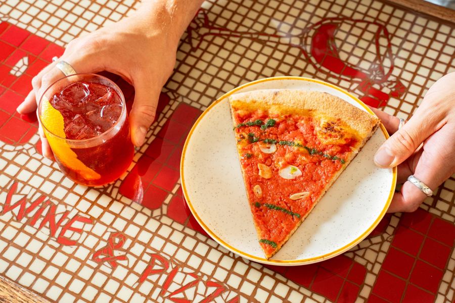 A Negroni and a slice of tomato pie on Frenzie's red-and-white tiled bar