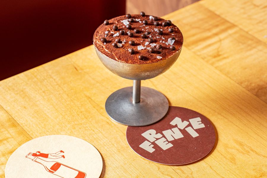 Tiramisu in a footed glass beside a Frenzie coaster