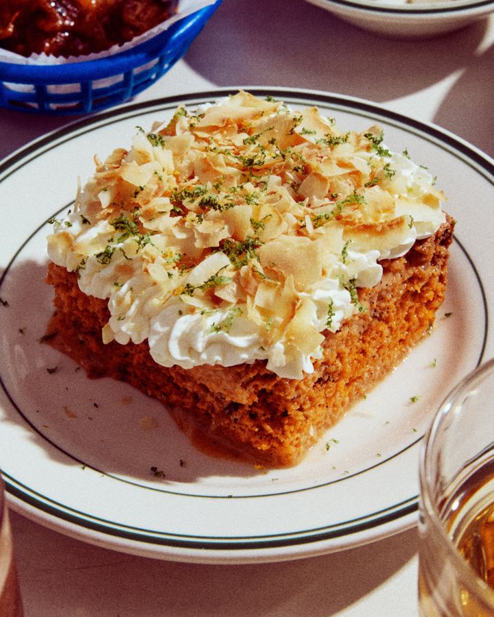 A slice of cake topped with whipped cream and toasted coconut at Golden Diner