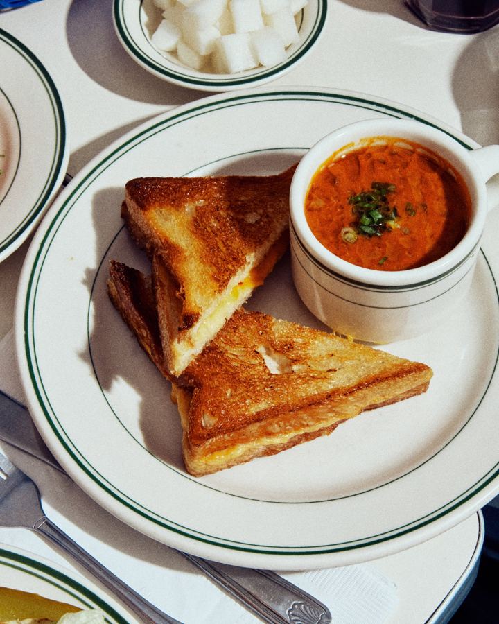 A grilled cheese cut into triangles with a mug of tomato soup at Golden Diner