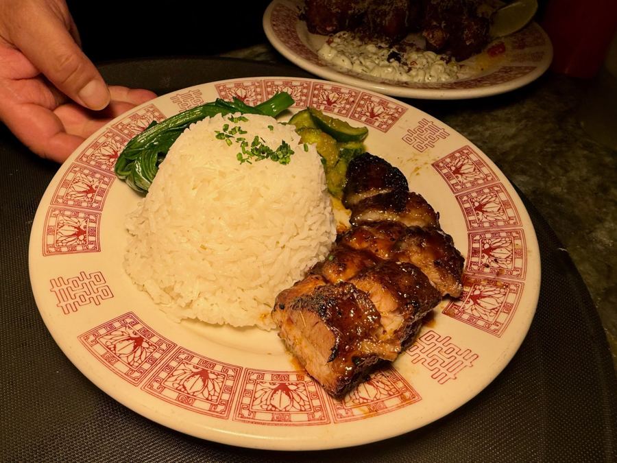 Char siu pork belly with rice and greens on a red-rimmed plate at Kelang in Greenpoint