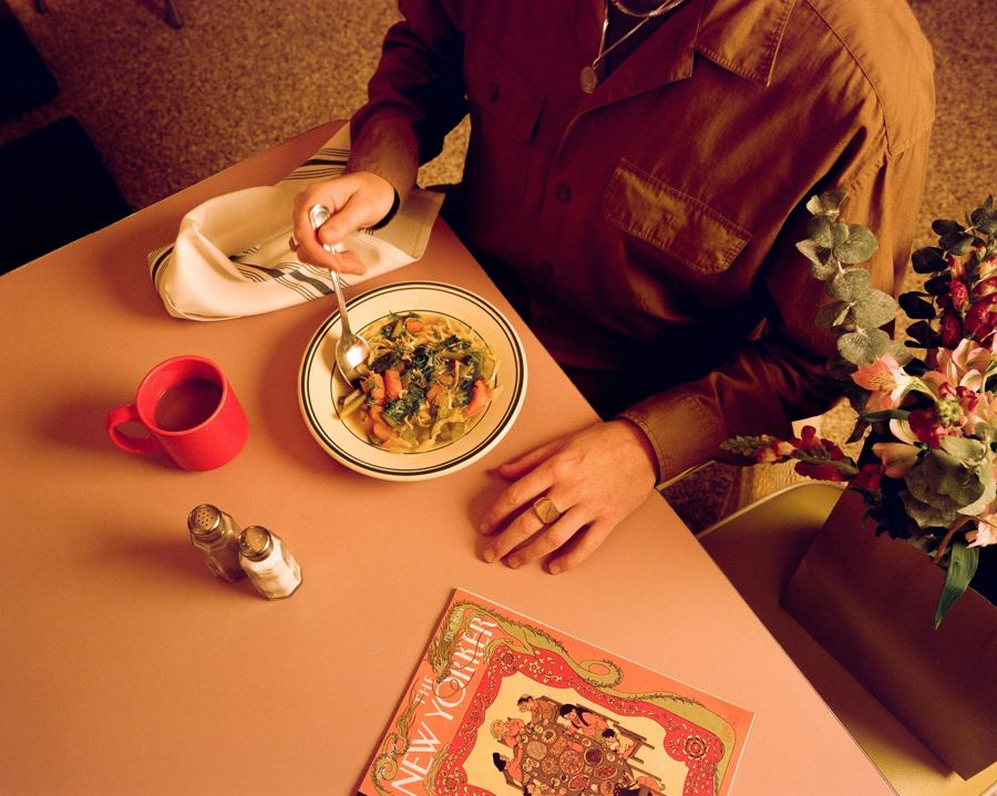 A bowl of soup, coffee and a menu on a pink tabletop at Kellogg's Diner in Williamsburg