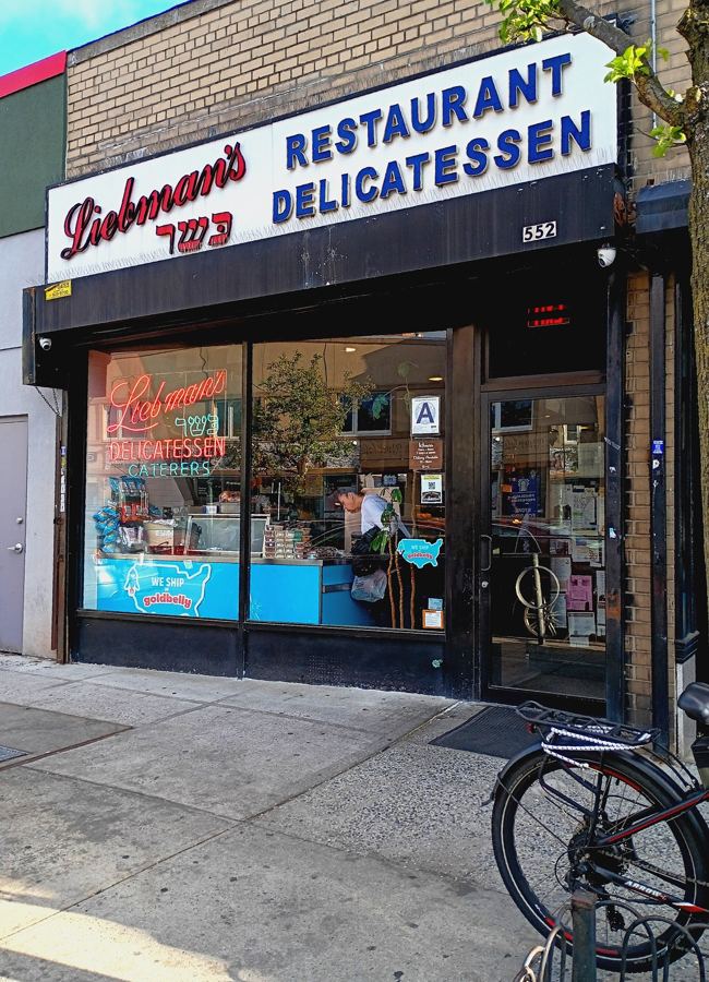The storefront of Liebman's Restaurant Delicatessen at 552 West 235th Street in Riverdale, the Bronx, with its red script sign and neon in the window