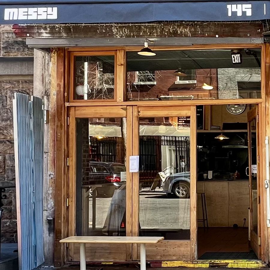 Messy's wood-framed storefront at 149 Sullivan Street, its name on the navy awning and a bench out front