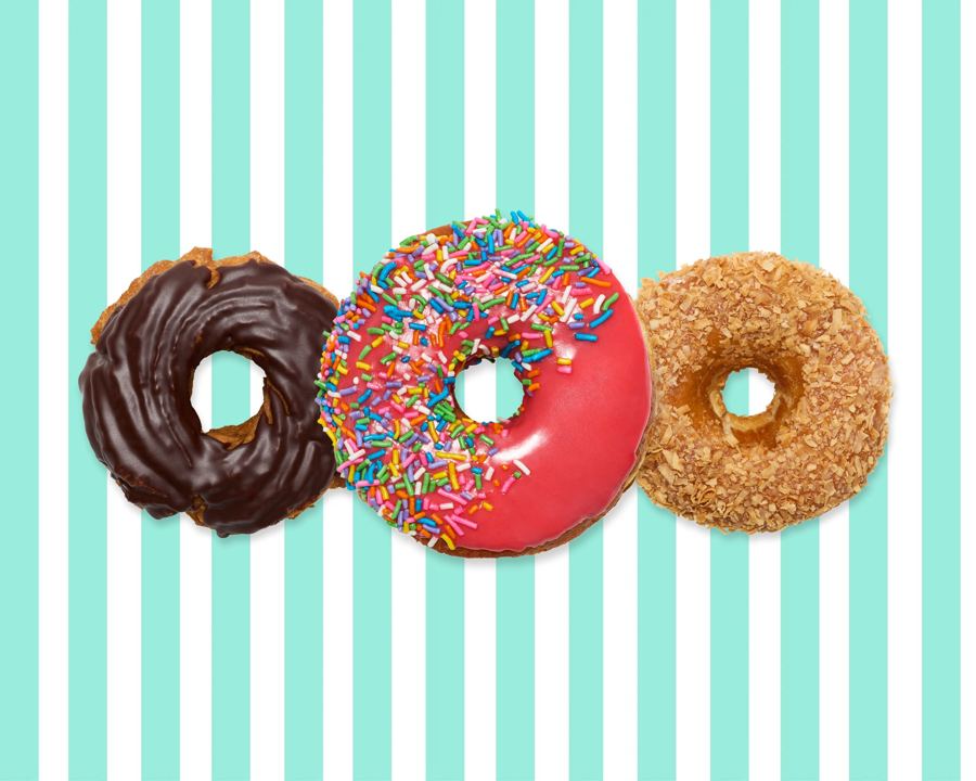 A chocolate-glazed cruller, a pink sprinkle donut and a crunch-topped donut from Peter Pan Donut & Pastry Shop on its mint-striped background
