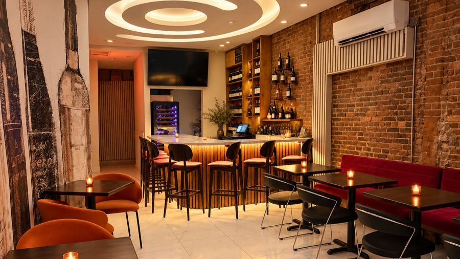 Pour BX's room on Bruckner Boulevard: exposed brick, a lit wine wall, bar stools and a red banquette