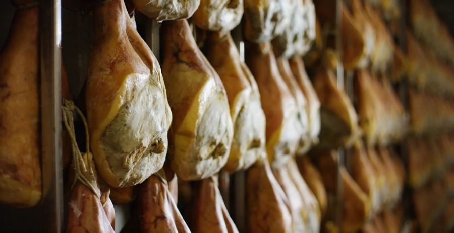 Legs of prosciutto hanging to cure in rows at Prosciutto in the East Village