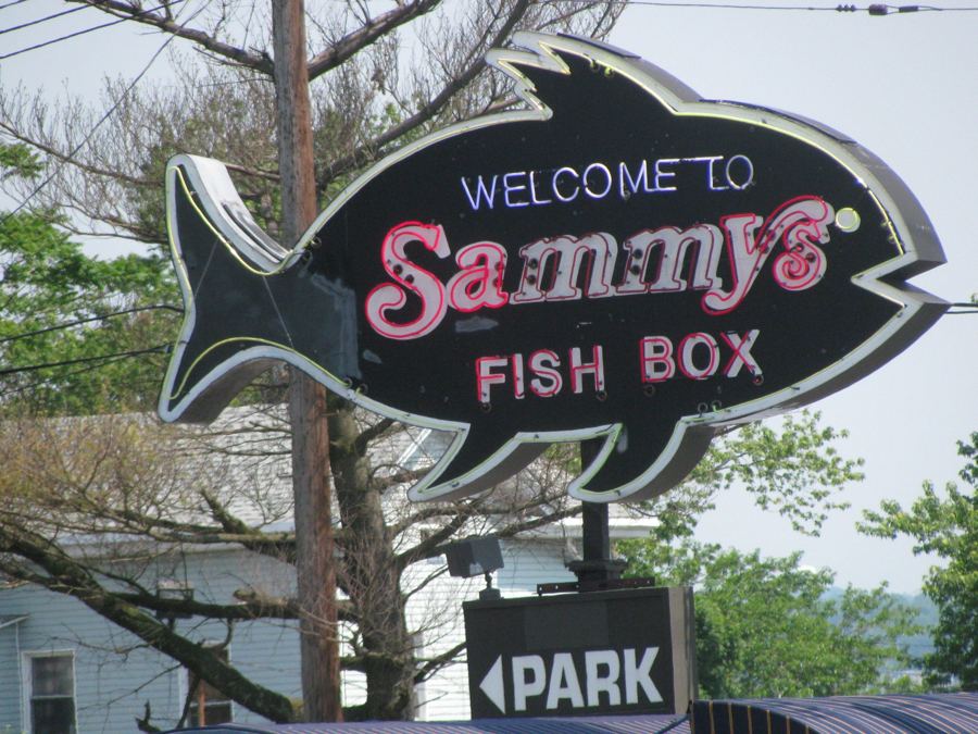 The fish-shaped neon 'Welcome to Sammy's Fish Box' sign on City Island Avenue