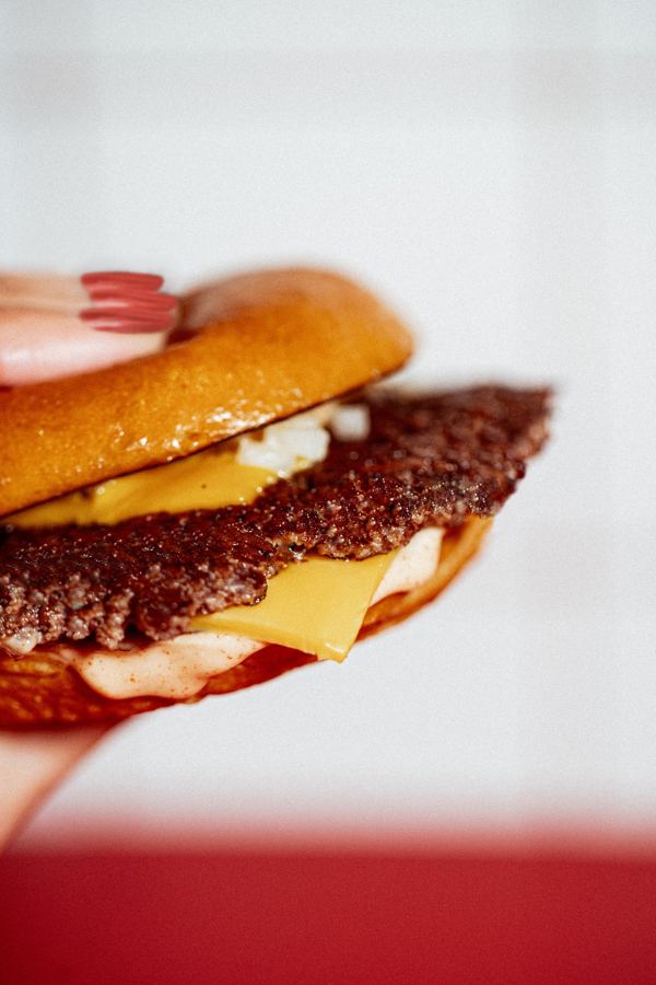 A close-up of a Skinny Louie double smash burger with American cheese