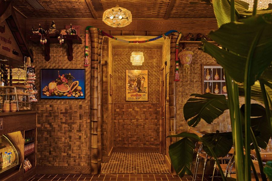 The back room at Thai Diner: woven bamboo walls, hanging lanterns, framed Thai posters and big tropical leaves