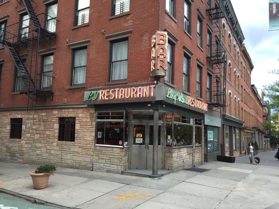 The corner of Atlantic Avenue and Henry Street, with the Long Island Bar's vintage neon RESTAURANT and BAR signs over its stone-clad storefront