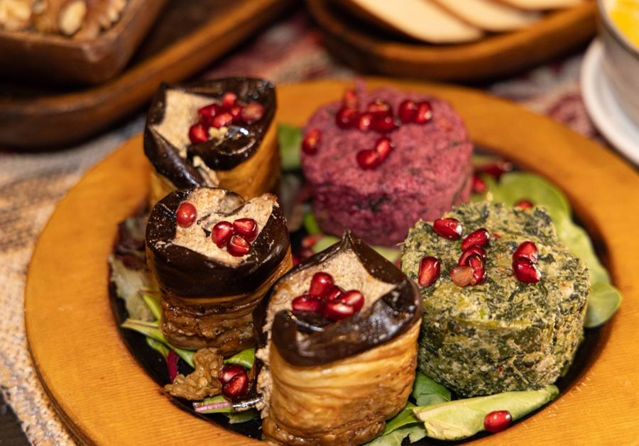 Eggplant rolls with walnut paste, beet and spinach pkhali topped with pomegranate at Toné Café