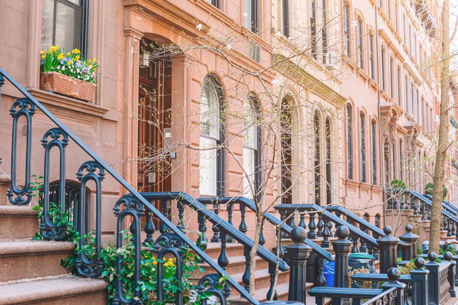 Federal-era rowhouses with stoops and ivy on a quiet West Village side street in late afternoon light