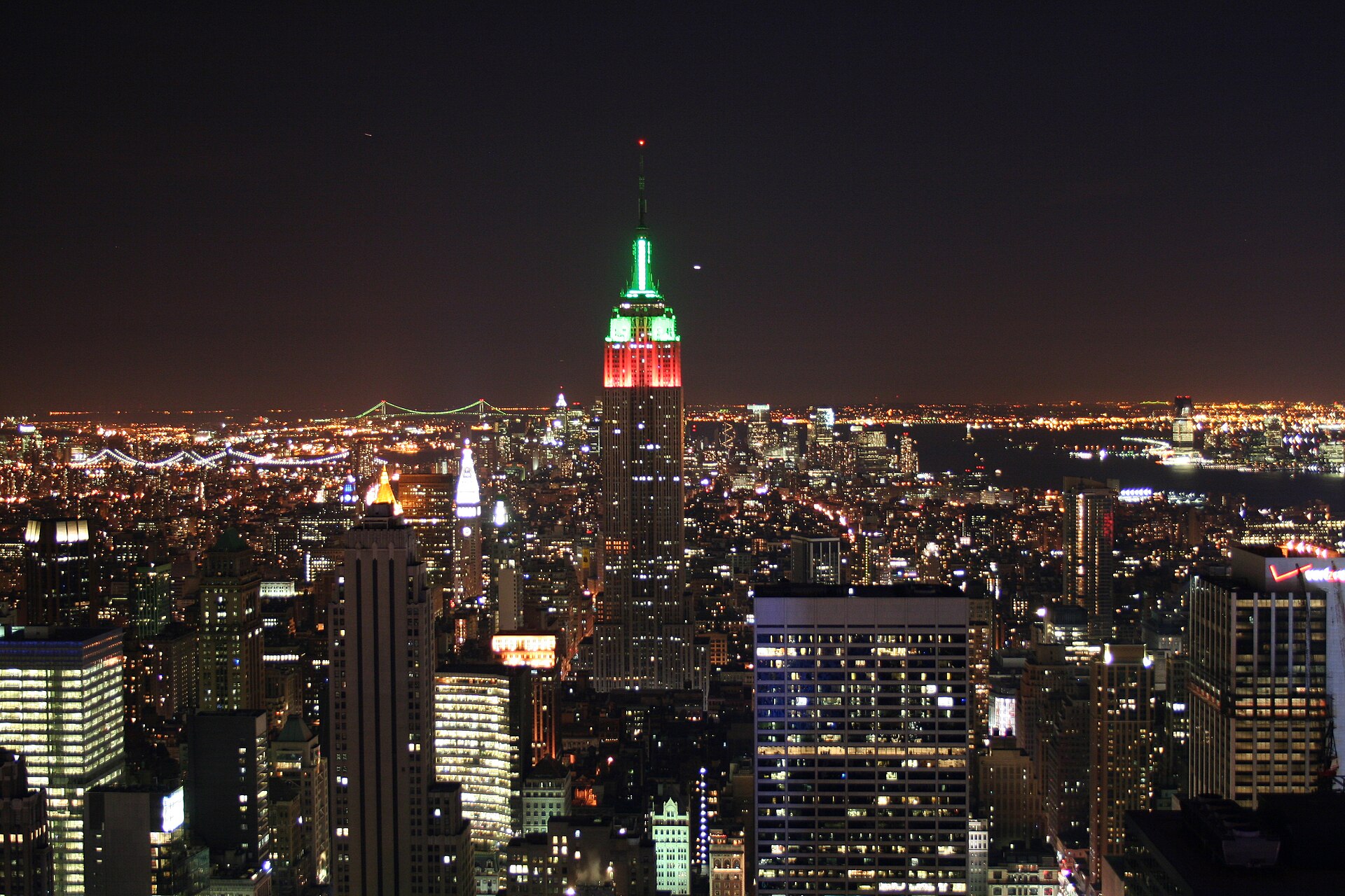 The Empire State Building lit red and green over Midtown at night